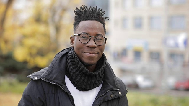 非洲男子学生微笑肖像在寒冷的欧洲秋天城市视频素材