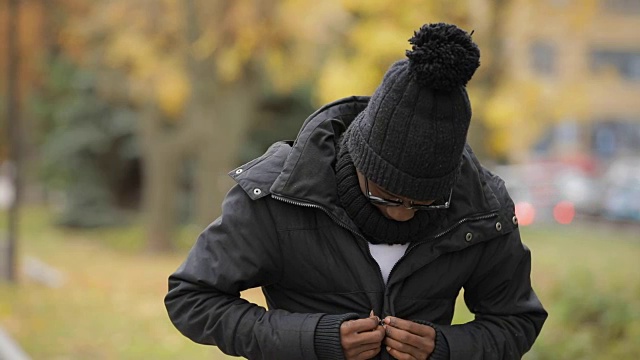 非洲人在寒冷的欧洲城市戴着帽子和兜帽视频素材