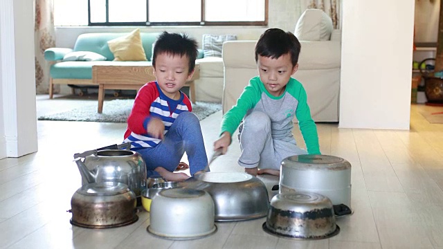 两个兄弟在地板上玩着锅碗瓢盆视频素材