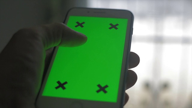 近距离触摸智能手机，绿色屏幕显示。视频下载