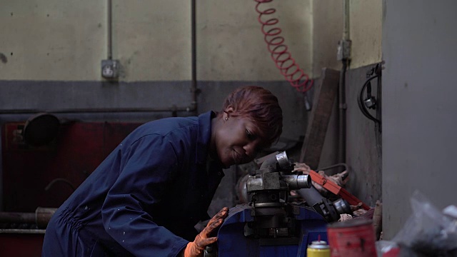 女机械师检查发动机的一部分视频素材