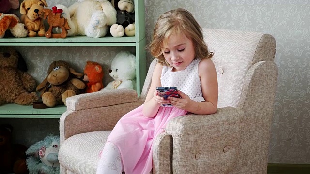 小女孩在玩和触摸手机视频素材