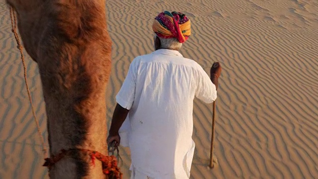 在沙漠沙丘上骑骆驼的观点视频下载