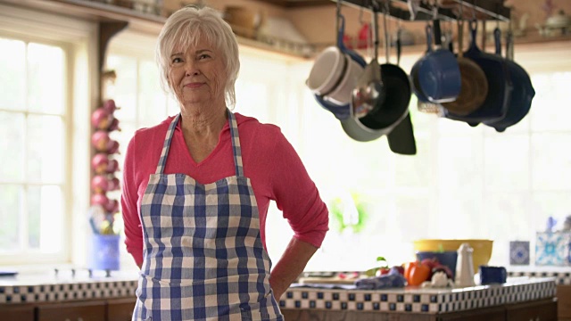 在厨房系围裙的老妇人视频素材