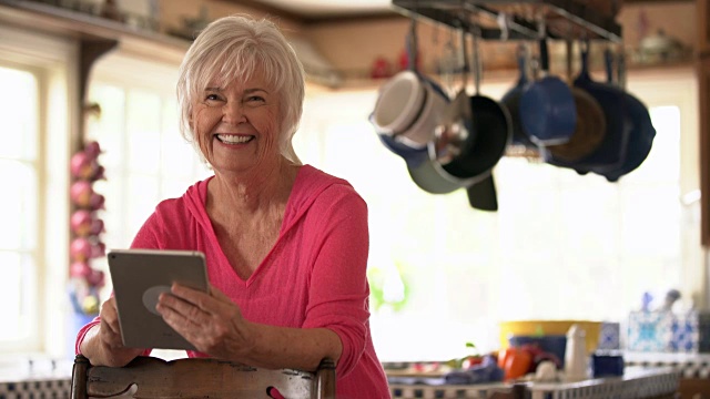 MS资深女性在厨房使用她的数字平板电脑视频素材