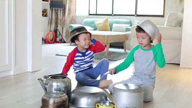 两个兄弟在地板上玩着锅碗瓢盆视频素材