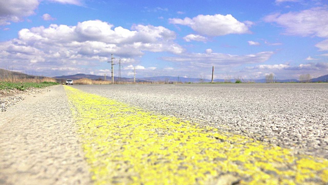 高速公路上的车，低角度拍摄高速公路上通过的车，4k景深拍摄，聚焦于沥青和黄线视频下载