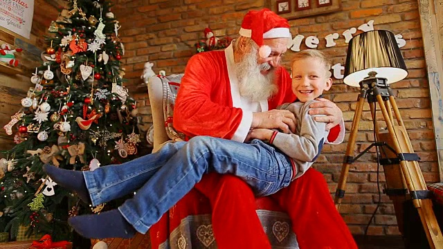 圣诞老人讲故事，和快乐的男孩玩视频素材