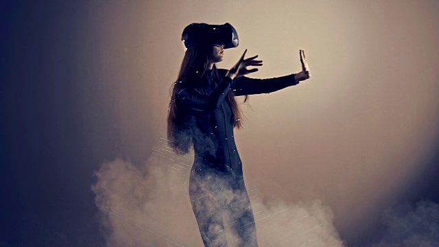 迷人的女孩年轻的时尚模特戴着VR头戴在专业工作室用烟雾和激光拍摄的网络凉爽的感觉。Prores视频素材