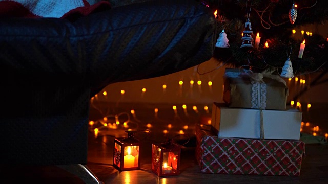 一个小女孩晚上睡在圣诞树下的地毯下的沙发上视频下载