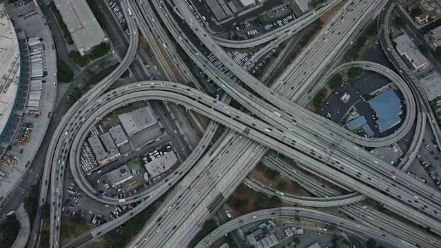 在加州洛杉矶的110号州际公路和10号州际公路交汇处的空中俯瞰立交桥，高速公路上的通勤交通，摄像机放大到高速公路交叉路口的近距离镜头，美国加州洛杉矶视频素材