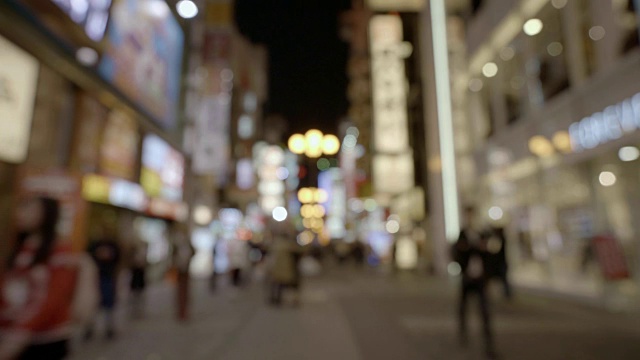 日本大阪南波区行人在街上行走的抽象模糊背景和夜间照明视频下载