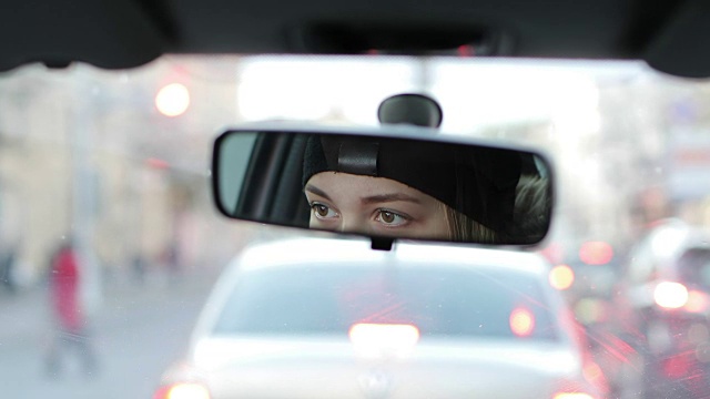 从汽车后视镜里可以看到女性的眼睛。视频素材