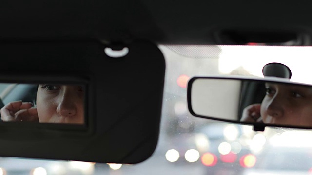 一个年轻女子或女孩坐在车里照镜子看自己。视频素材