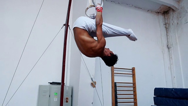 男子体操运动员在体操吊环上做练习视频素材