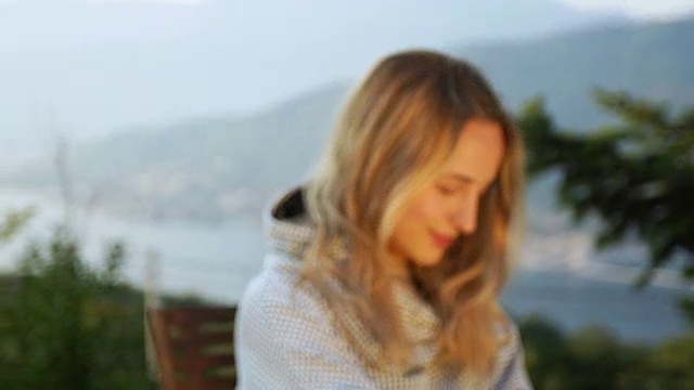 女人穿着舒适的毛衣放松在院子里视频下载