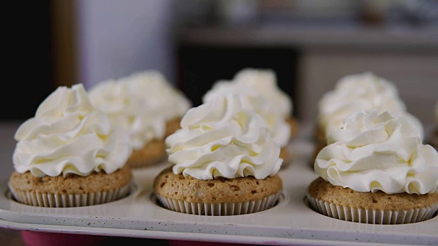杯型蛋糕奶油。奶油奶油配美味的松饼，家庭烘焙概念视频素材