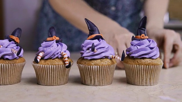 用糖衣帽和腿装饰杯形蛋糕。松饼像女巫。万圣节的概念视频素材