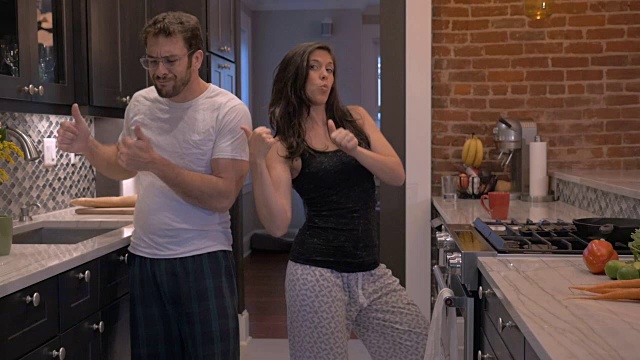 一对夫妇在现代化的厨房里一起跳舞视频素材