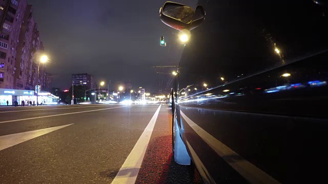 快速城市驾驶夜间道路POV通过城市在夜间时间推移左侧的汽车。低角度的观点视频素材