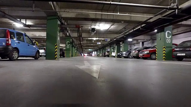 汽车驾驶pov在一个繁忙的停车场在城市购物中心，低角度的视角视频素材