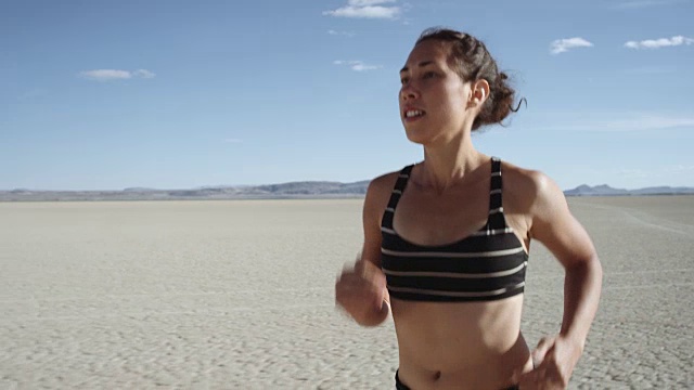 SLO MO:一个有魅力的女人在沙漠中奔跑的特写视频素材