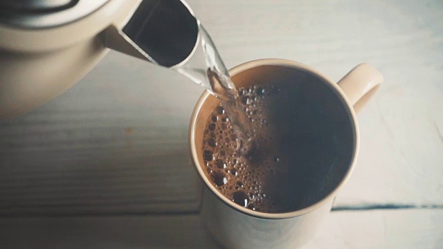 用水壶里的热水把咖啡倒进陶瓷杯里视频素材