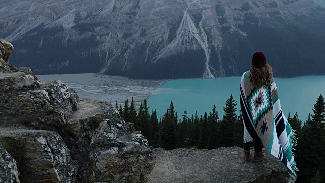 一位裹着毯子的年轻女子俯瞰班夫的佩托湖视频素材