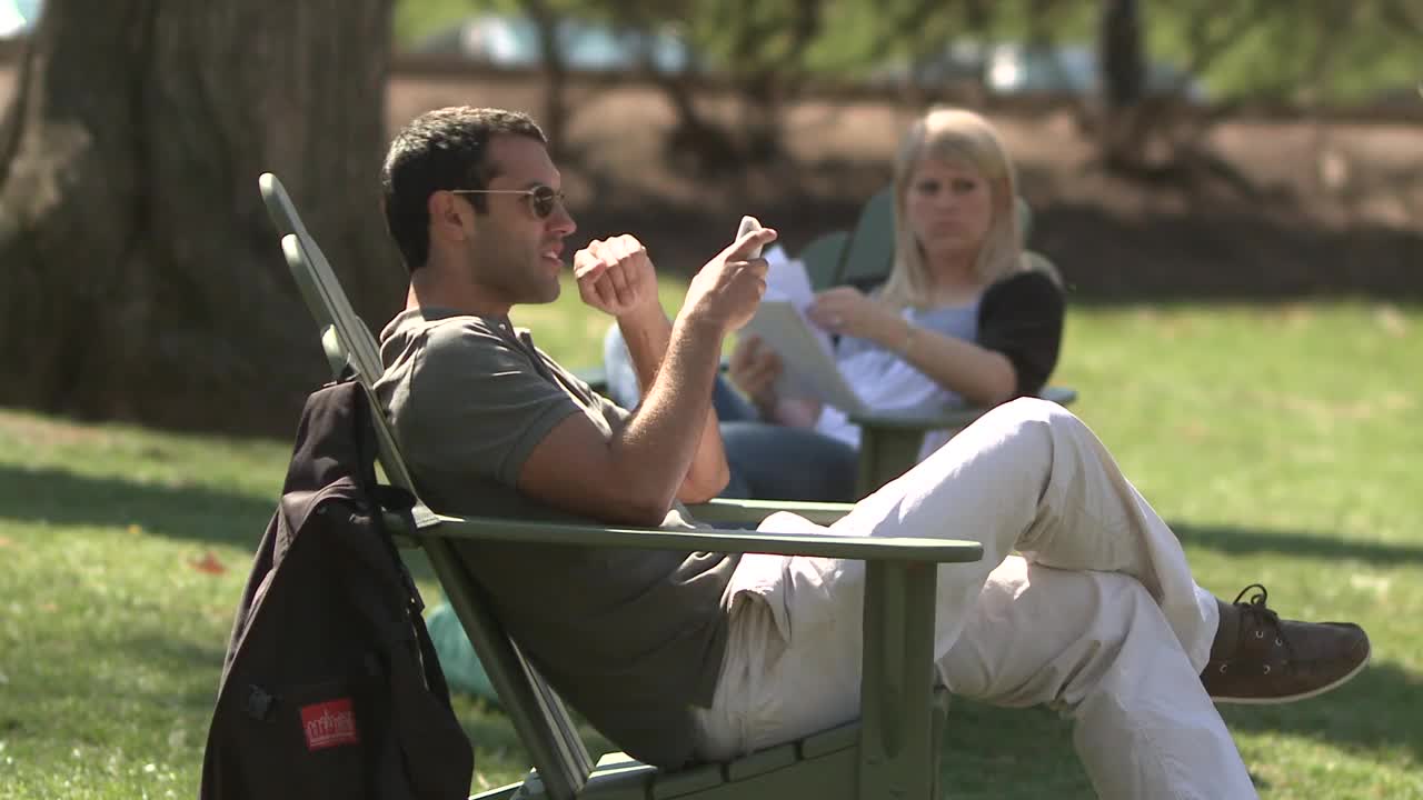 美国宾夕法尼亚州伯利恒，两名学生坐在校园草坪上的躺椅上视频下载