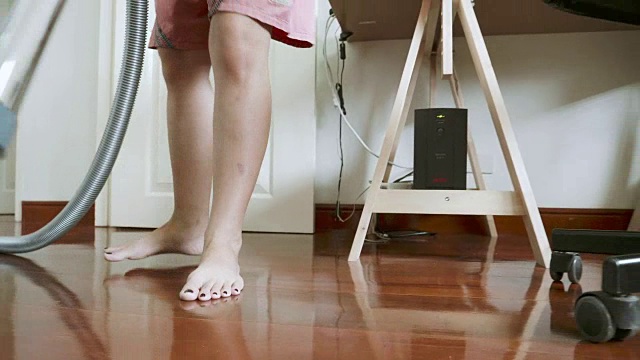 稳定的妇女用吸尘器清扫地面的镜头视频素材