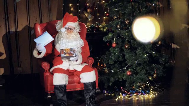 圣诞老人在圣诞树下放了一个礼物盒。视频素材