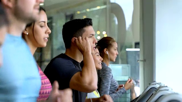 人们在运动中心的跑步机上训练视频素材