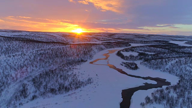 图片:蜿蜒的河流流过拉普兰冬季美丽的丘陵景观视频素材