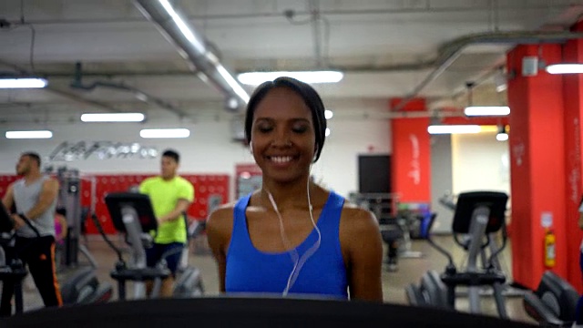 拉丁美洲黑人妇女在健身房跑步机上跑步视频素材