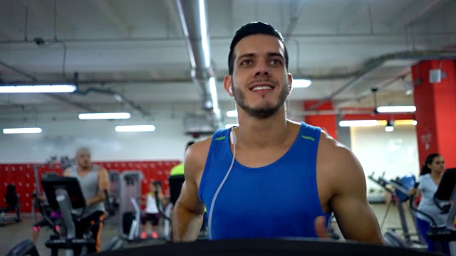 在健身中心跑步机上跑步的帅哥视频素材