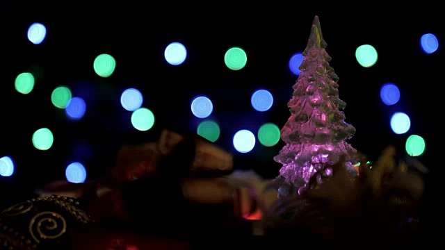 圣诞礼盒，彩球和闪烁灯圣诞树上五颜六色的散景灯背景视频素材