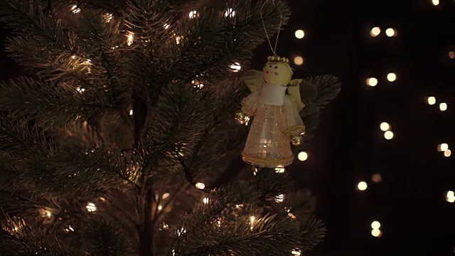 女神仙装饰挂在圣诞树上，以散景灯为背景视频素材