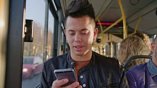 一个年轻人在公交车上用智能手机视频素材