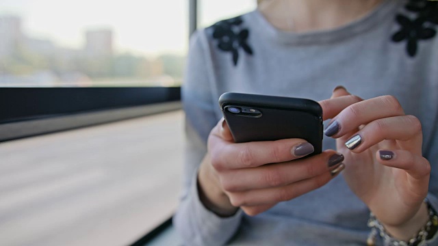 一位年轻女士在公交车上使用智能手机视频素材