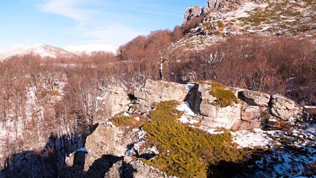 一个女人站在山顶上，伸开双臂视频素材