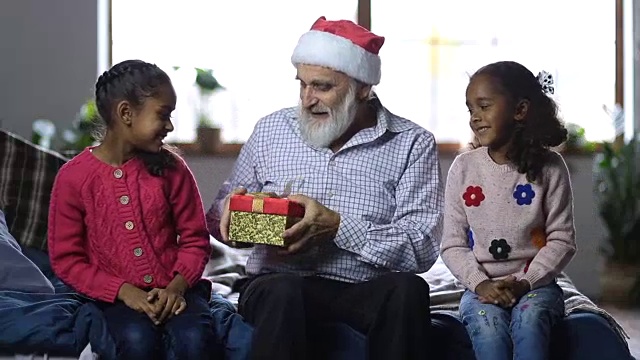 快乐的爷爷给孩子们圣诞礼物视频素材