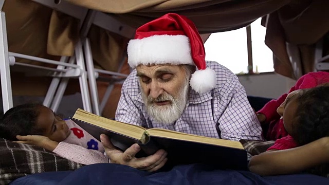 爷爷和孩子们在圣诞夜读童话故事视频素材