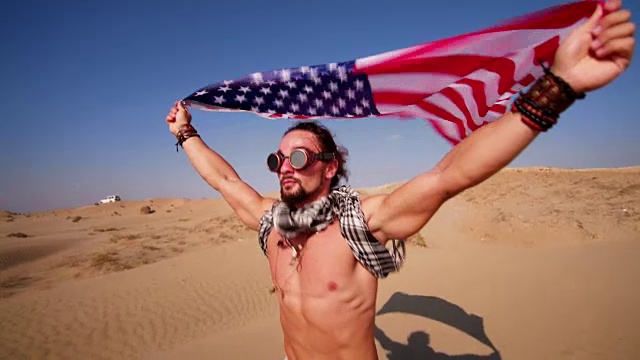 一个戴着蒸汽朋克眼镜挂着美国国旗的人在沙漠里跑视频下载