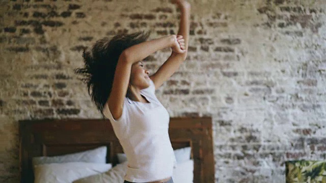 迷人的混合种族年轻快乐的女人有乐趣跳舞附近的床在家里视频下载