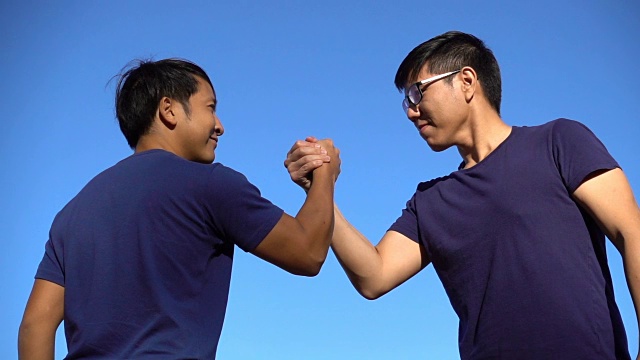 两名亚洲男子用摔跤的方式握手视频素材
