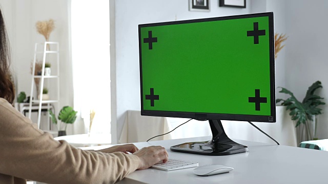 在家里用绿屏电脑的女人，慢镜头视频素材