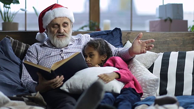 爷爷给瞌睡的孩子读睡前故事视频素材