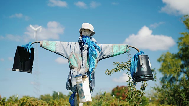 一个稻草人映衬着蓝天和白云。使花园远离鸟类和其他害虫视频素材