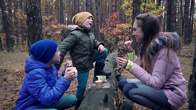 孩子们在森林里散步时吃零食视频素材