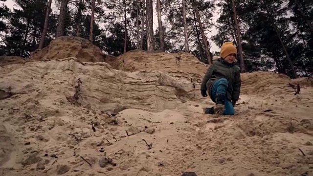小男孩从沙崖上跑出来的慢镜头视频素材